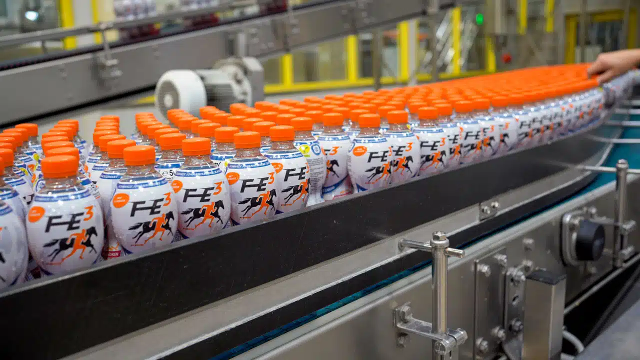 Getränkeflaschen auf Produktionsband in Fabrik.